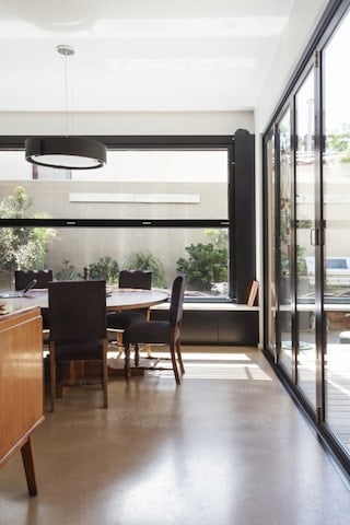 Moderne eetkamer met gepolijste betonvloer en bi-fold glasdeuren