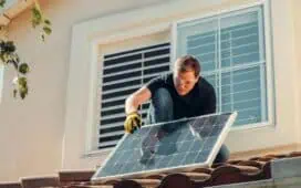 Monteur van zonnepanelen op een dak die een zonnepaneel installeert